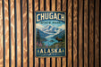 A vintage metal sign for Chugach State Park in Alaska, featuring a scenic mountain landscape with a moose in the foreground.