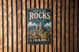 A vintage-style metal sign for the City of Rocks National Reserve in Idaho, featuring a mountain landscape and the text "City of Rocks National Reserve Idaho" prominently displayed.