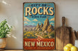 A vintage-style sign for City of Rocks State Park in New Mexico, featuring a desert landscape with mountains and a path leading through the scenery.