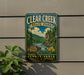 A vintage-style metal sign for Clear Creek State Park in Pennsylvania, featuring a scenic landscape with a river, trees, and mountains.