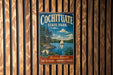 A vintage metal sign for Cochitiate State Park, featuring a scenic image of a lake with a sailboat, surrounded by trees and mountains.