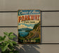 A vintage-style sign for Coeur d'Alene Parkway, displaying a scenic mountain landscape with a winding road and a lake.
