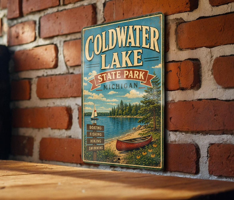A vintage metal sign for Coldwater Lake State Park in Michigan, featuring a scenic illustration of a lake, boat, and surrounding landscape.