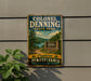 A vintage-style metal sign for Colonel Denning State Park, featuring a scenic landscape with a lake, mountains, and trees.
