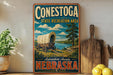 A vintage-style sign for Conestoga State Recreation Area in Nebraska, featuring a wagon on a grassy field with a river in the background.
