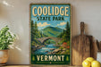 A vintage-style sign for Coolidge State Park in Vermont, featuring a scenic illustration of a stone bridge over a river surrounded by pine trees and mountains.