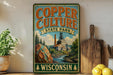 A vintage-style sign for Copper Culture State Park in Wisconsin, featuring a scenic illustration of a mining town and a river.