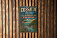 A vintage metal sign for Cossatot River State Park-Natural Area in Arkansas, featuring a scenic illustration of the river and surrounding landscape.