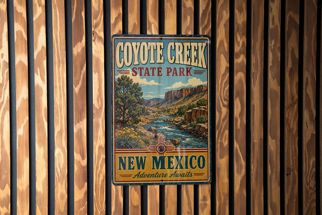 A vintage-style metal sign for Coyote Creek State Park in New Mexico, featuring a scenic landscape with a river and mountains.