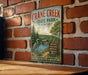 A vintage metal sign for Crane Creek State Park in Ohio, featuring a scenic illustration of a lake, forest, and wildlife.