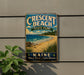 A vintage metal sign for Crescent Beach State Park in Maine, featuring a scenic beach landscape with a pine tree and waves in the background.