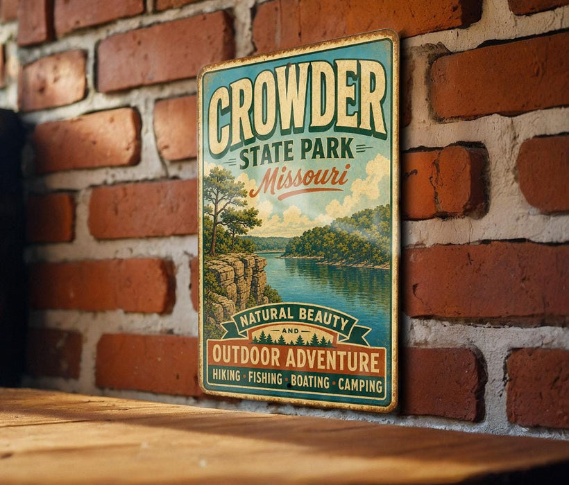 A vintage metal sign for Crowder State Park in Missouri, featuring a scenic landscape with a lake and mountains, is displayed on a brick wall.