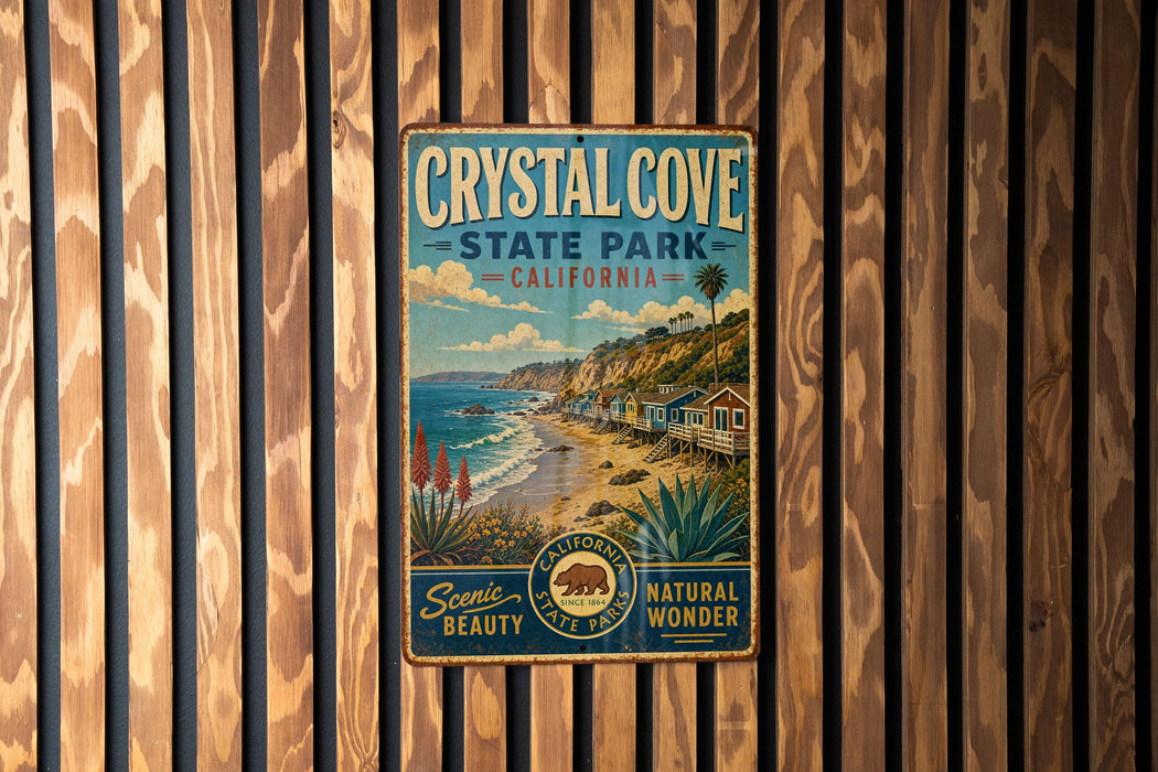 A vintage-style metal sign for Crystal Cove State Park, California, featuring a scenic beach landscape with palm trees and a house on the shore.
