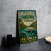 A vintage-style metal sign for Crystal River Preserve, featuring a manatee and surrounded by a tropical landscape, is displayed on a gray countertop.