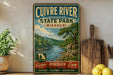 a vintage-style sign for Cuivre River State Park, Missouri, with a scenic illustration of a river and forest landscape. The sign is displayed on a shelf next to a wooden cutting board and a potted plant, creating a rustic and nature-inspired setting.
