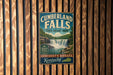 A vintage metal sign for Cumberland Falls State Resort Park in Kentucky, featuring a waterfall and lush greenery.