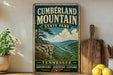 A vintage-style metal sign for Cumberland Mountain State Park, featuring a scenic mountain landscape with a river and pine trees.