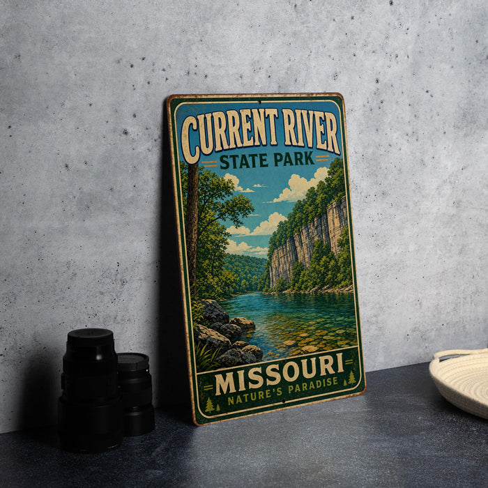 A vintage-style sign for Current River State Park in Missouri, featuring a scenic illustration of a river surrounded by lush greenery and rocky cliffs.