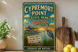 A vintage-style sign for Cypremont Point State Park in Louisiana, featuring a blue heron and a wooden sign with text.