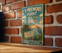 A vintage-style metal sign for Cypremont Point State Park in Louisiana, featuring a scenic illustration of a coastal landscape with a crane and a wooden cabin.