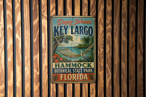 A vintage metal sign for Key Largo, a hammock botanical park in Florida, is displayed on a wooden wall.