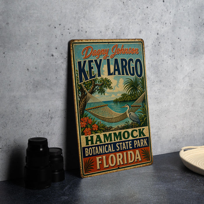 A vintage-style metal sign for Key Largo, a hammock park in Florida, featuring a tropical beach scene with palm trees and a bird.