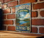 A vintage metal sign for Dainingfield State Park in Texas, featuring a scenic landscape with a lake and trees.