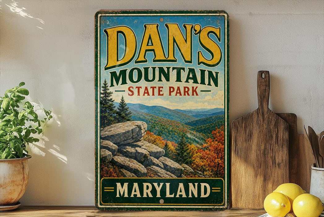 A vintage metal sign for Dan's Mountain State Park in Maryland, featuring a scenic mountain landscape with pine trees and rocky outcroppings.