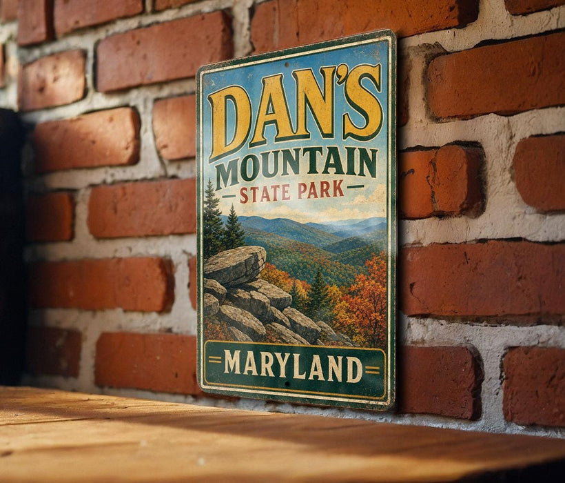 A vintage metal sign for Dan's Mountain State Park in Maryland, featuring a scenic mountain landscape with pine trees and rocky outcroppings.