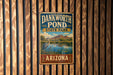 A vintage metal sign for Dankworth Pond State Park in Arizona, featuring a scenic landscape with a heron and a pond.