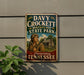 A vintage metal sign for Davy Crockett Birthplace State Park in Laurenceburg, Tennessee, featuring an illustration of a man in historical attire holding a rifle.