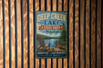 A vintage metal sign for Deep Creek Lake State Park in Maryland, featuring a scenic image of a lake, mountains, and a canoe.