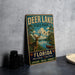 A vintage metal sign for Deer Lake State Park in Florida, featuring a deer and a canoe, is displayed on a gray countertop.