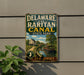 A vintage metal sign for Delaware and Raritan Canal State Park, featuring a scenic image of a canal and a house.