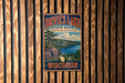A vintage-style metal sign for Devil's Lake State Park in Wisconsin, featuring a scenic landscape with a lake, mountains, and a tree.