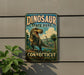 A vintage-style sign for Dinosaur State Park in Connecticut, featuring a large illustration of a T-Rex dinosaur in a lush, prehistoric landscape.