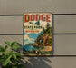 A vintage Dodge sign for State Park Michigan, featuring a scenic image of a cliff overlooking a lake.