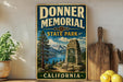 a vintage-style sign for Donner Memorial State Park in California, with a scenic landscape of mountains, pine trees, and a lake in the background.