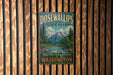 A vintage metal sign for Dosewallips State Park in Washington, featuring a scenic mountain landscape.