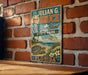 A vintage-style metal sign with the name "Dr. Julian G. Bruce" and the location "St. George Island, Florida" displayed on it, hanging on a brick wall.