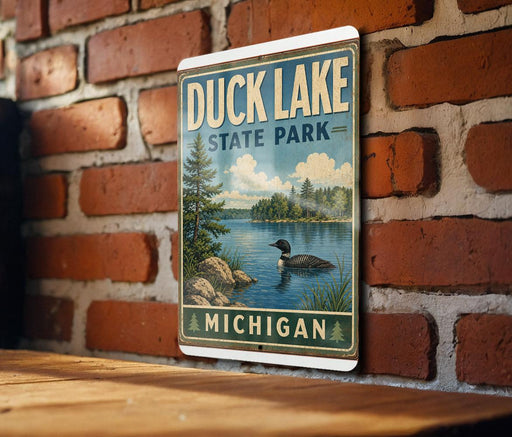 A vintage-style metal sign for Duck Lake State Park in Michigan, featuring a scenic illustration of a lake surrounded by trees and wildlife.