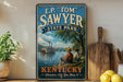 A vintage-style sign for E.P. "Tom" Sawyer State Park in Kentucky, featuring a river scene with a steamboat and two people sitting on a bench.