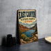 A vintage-style sign for East Canyon State Park in Utah, featuring a scenic landscape with mountains, a lake, and a boat on the water.