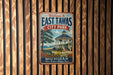 A vintage metal sign welcoming visitors to East Tawas City Park in Michigan, featuring a gazebo and a scenic waterfront view.