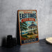 A vintage-style metal sign welcoming visitors to East Tawas City Park in Michigan, featuring a gazebo and a scenic waterfront view.