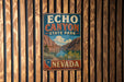 A vintage metal sign for Echo Canyon State Park in Nevada, featuring a scenic illustration of the canyon landscape.