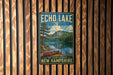 A vintage-style metal sign for Echo Lake State Park in New Hampshire, featuring a scenic landscape with a lake, mountains, and a canoe.