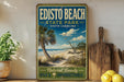 A vintage-style sign for Edisto Beach State Park in South Carolina, featuring a beach scene with palm trees and a clear blue sky.