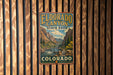 A vintage-style metal sign for Eldorado Canyon State Park in Colorado, featuring a scenic mountain landscape with a river and forest.