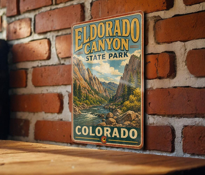 A vintage-style metal sign for Eldorado Canyon State Park in Colorado, featuring a scenic mountain landscape with a river and pine trees.